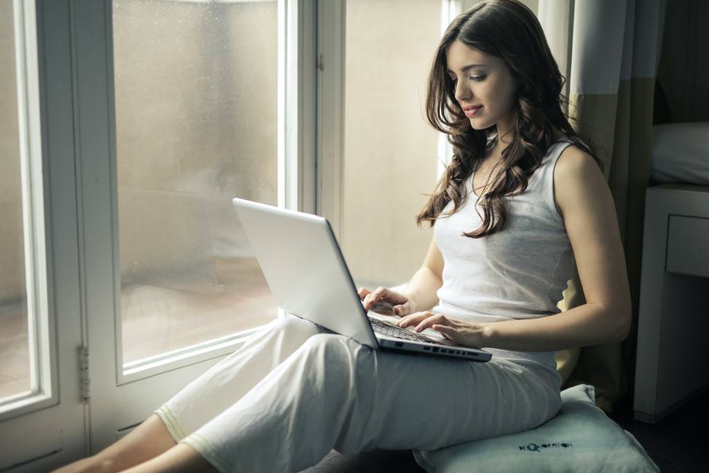 Femme devant son ordinateur se renseignant sur les démarches à effectuer pour obtenir un prêt hypothécaire.