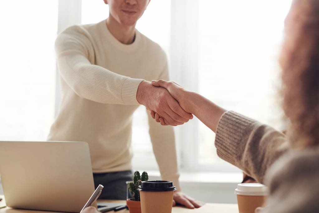 Image d'une femme et d'un homme se serrant la main. Cette image illustre un entretien entre un courtier et une cliente.